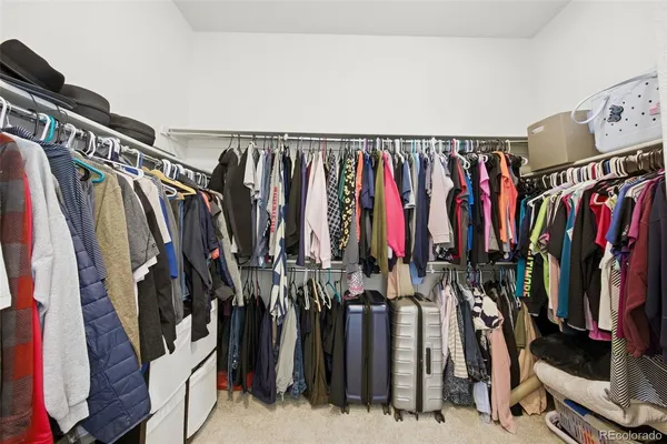 a view of walk in closet with clothes