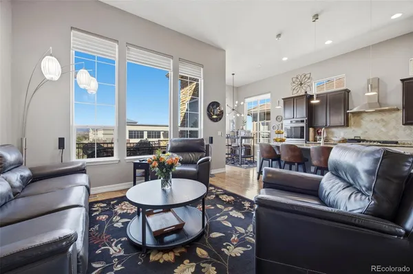 a living room with furniture kitchen view and a large window