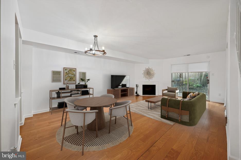 449 West School House Lane Philadelphia, PA 19144 - Photo 3 of 13 a living room with furniture a fireplace and a dining table with wooden floor