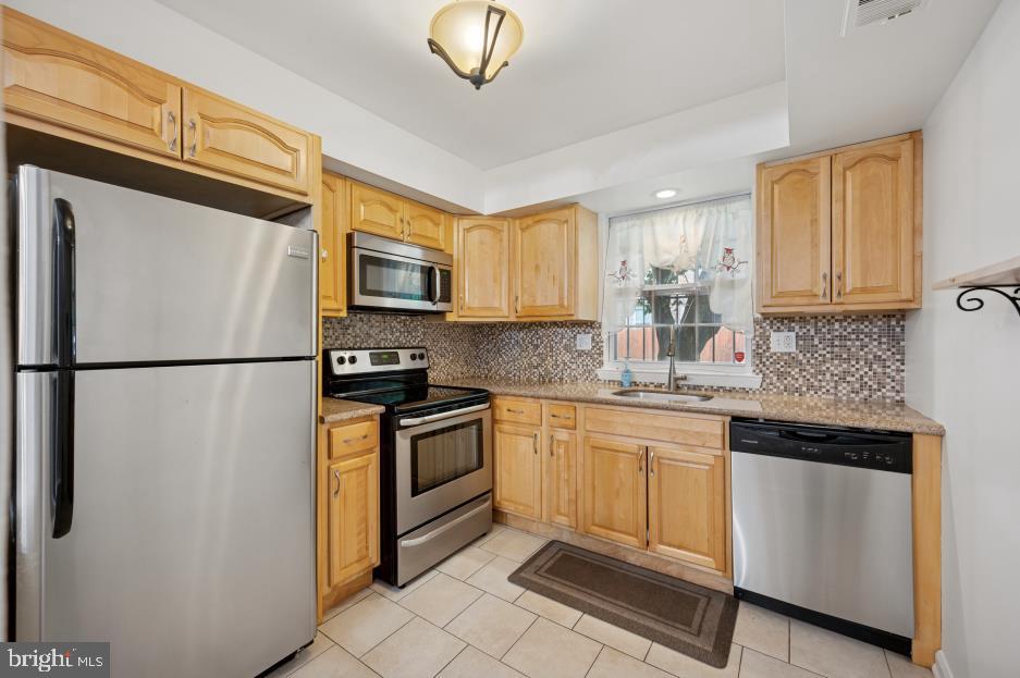449 West School House Lane Philadelphia, PA 19144 - Photo 8 of 13 a kitchen with stainless steel appliances granite countertop a refrigerator sink stove microwave and cabinets