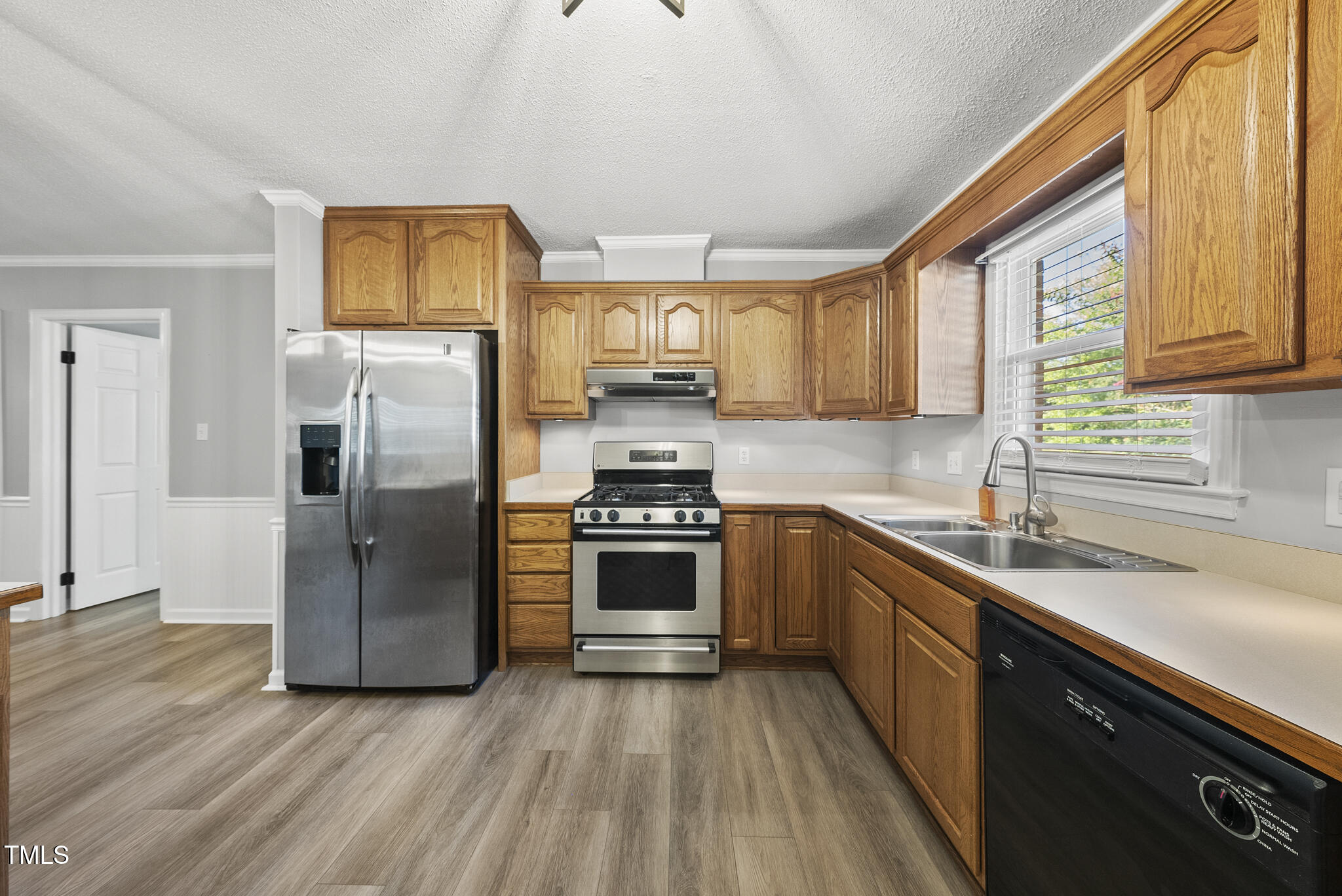4500 Castlebar Drive Raleigh, NC 27604 - Photo 16 of 36 a kitchen with stainless steel appliances granite countertop a refrigerator a sink dishwasher a stove with wooden cabinets and floor