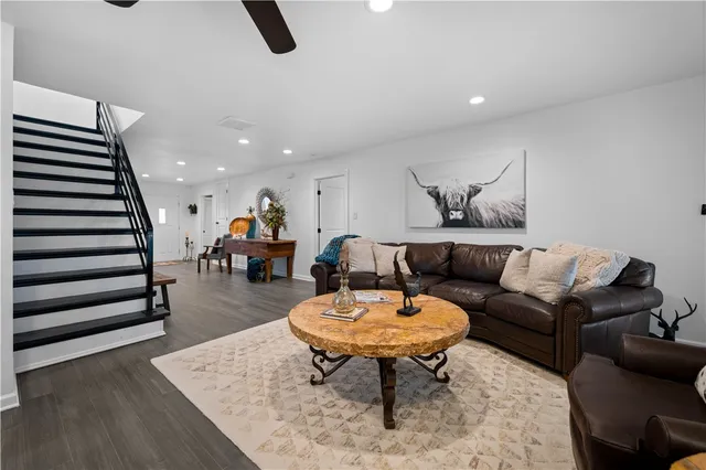 a living room with furniture and a dining table with wooden floor