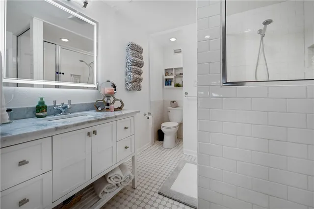 a bathroom with a granite countertop sink a toilet and mirror