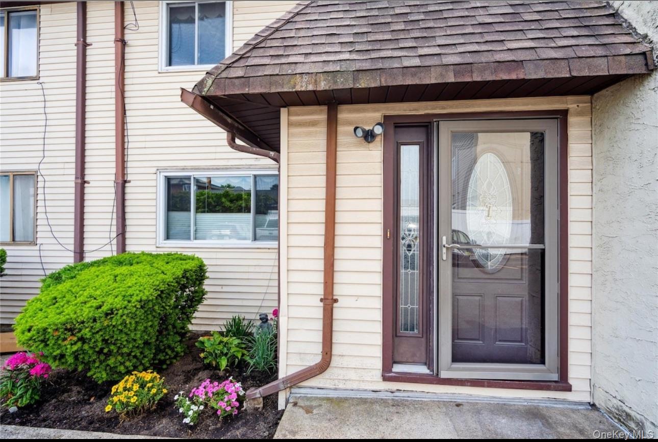 Doorway to property featuring roof with shingles