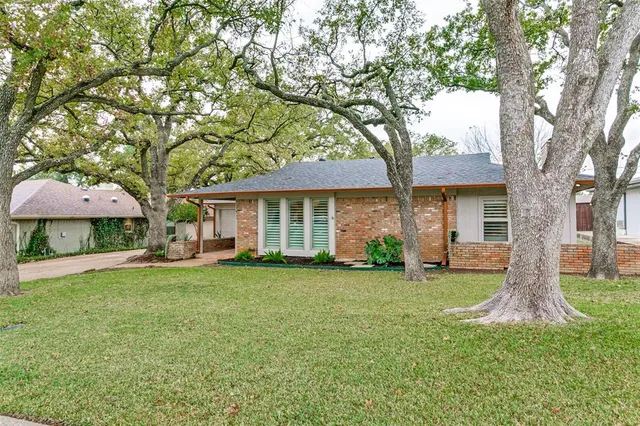 a front view of a house with a yard and trees