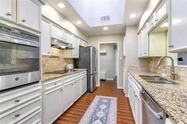 a kitchen with stainless steel appliances granite countertop a stove and a sink