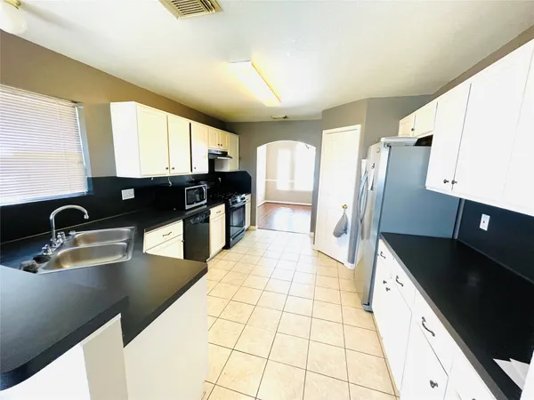 a kitchen with stainless steel appliances granite countertop a sink refrigerator and stove