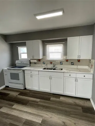 a kitchen with granite countertop white cabinets and white appliances