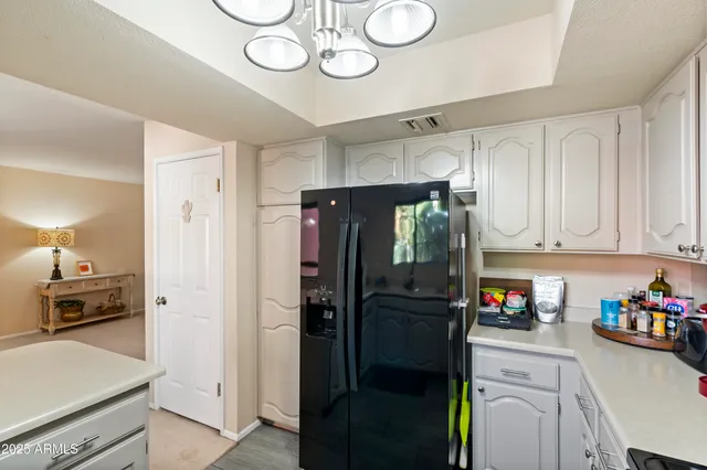 a kitchen with stainless steel appliances a sink a stove a refrigerator cabinets and a dining table