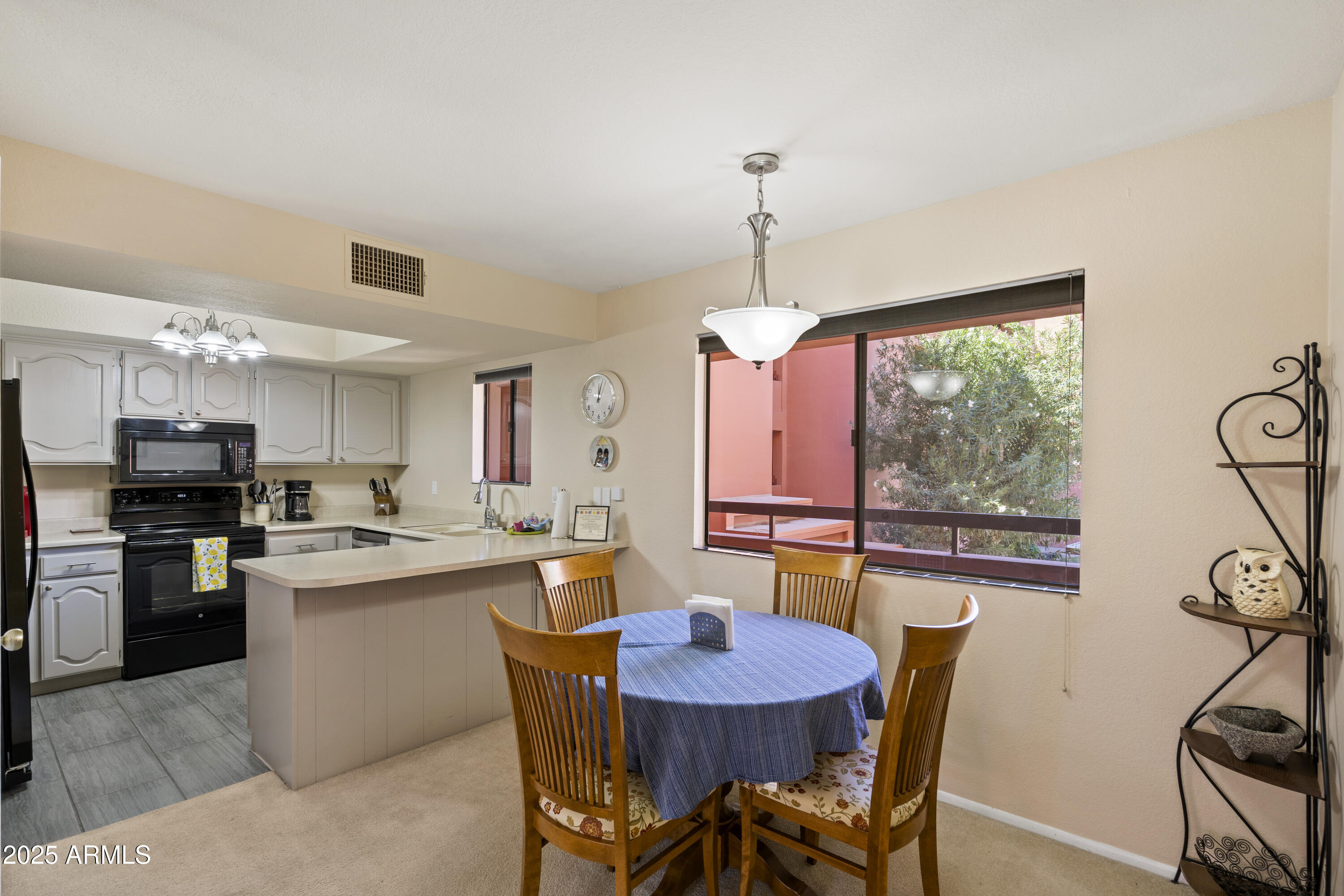 4303 East Cactus Road, Unit 222 Phoenix, AZ 85032 - Photo 15 of 38 a kitchen with kitchen island a stove a table and chairs in it