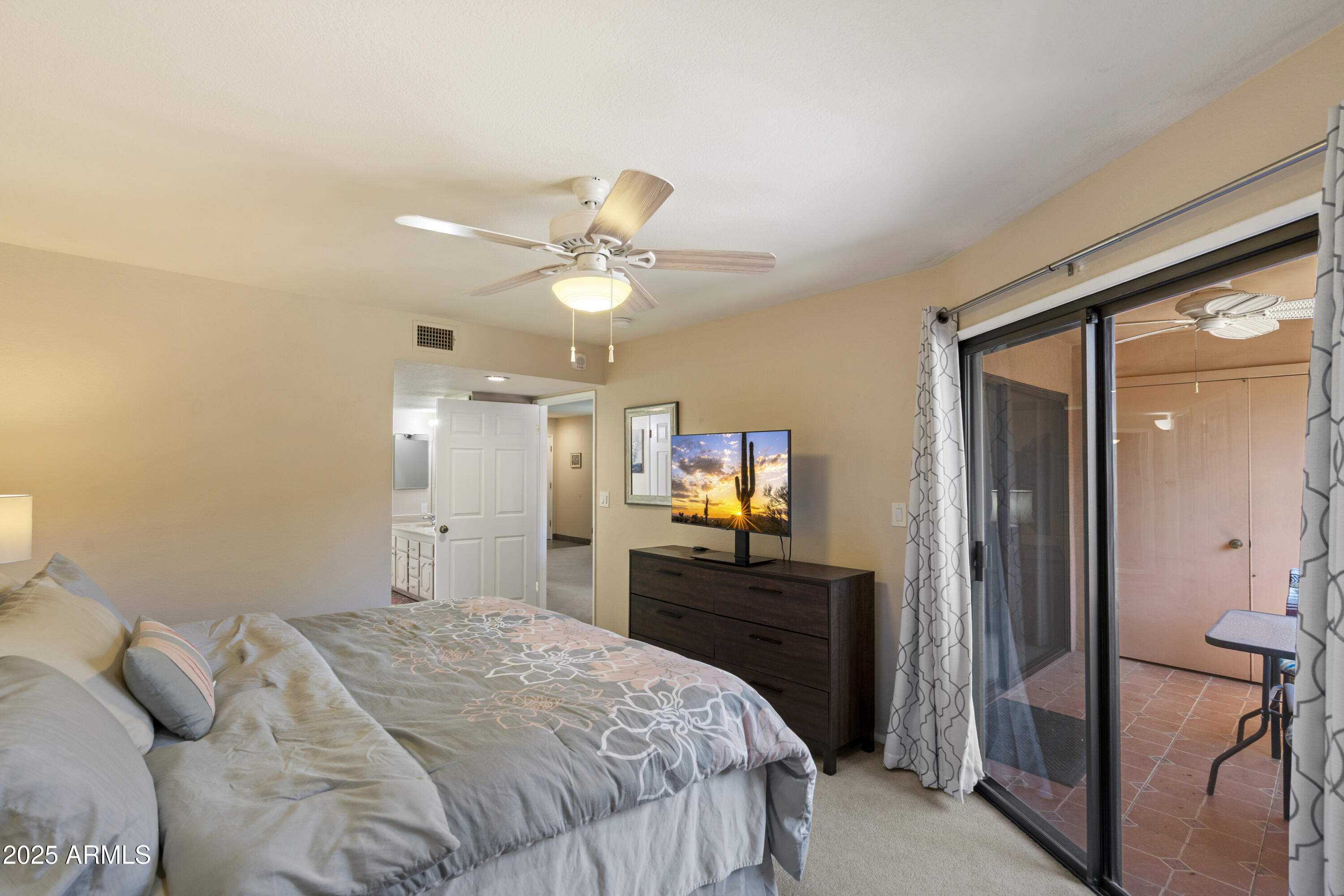 4303 East Cactus Road, Unit 222 Phoenix, AZ 85032 - Photo 16 of 38 a bedroom with a bed and a chandelier