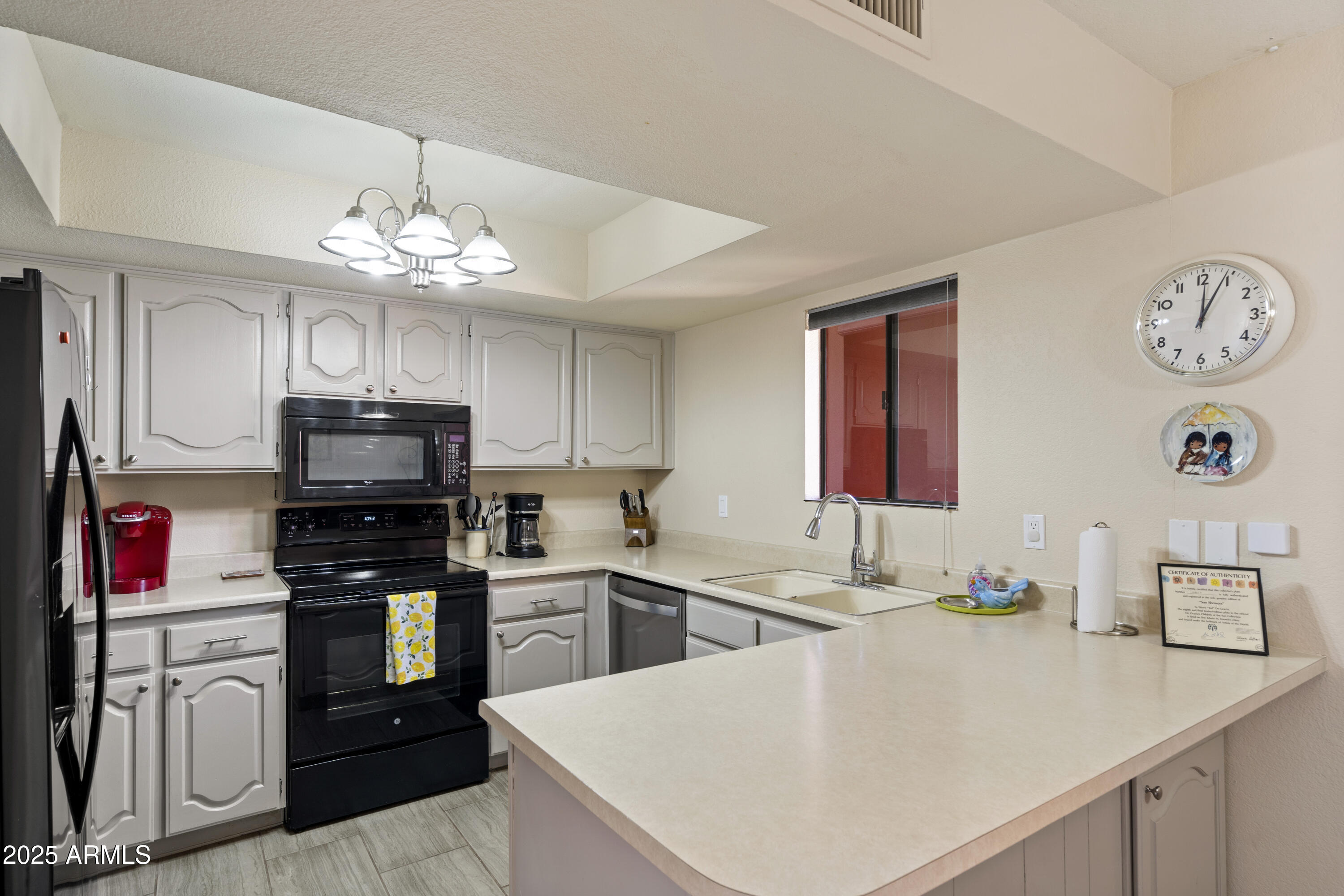 a kitchen with a refrigerator a stove top oven a sink dishwasher and a dining table with wooden floor