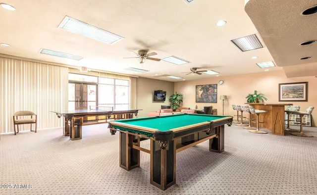 a room with pool table and large windows