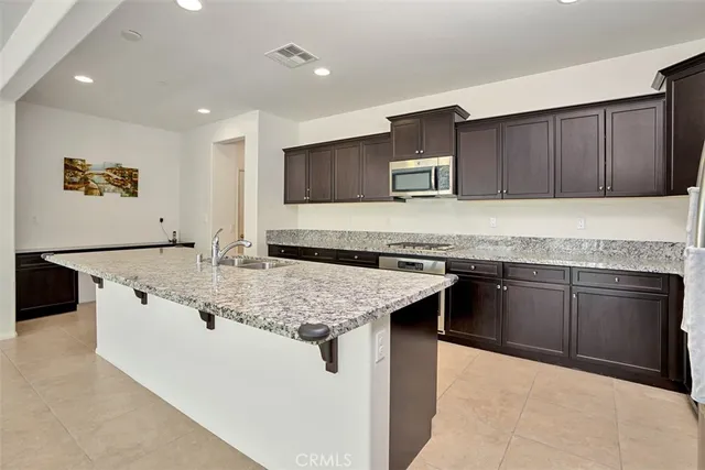 a kitchen with stainless steel appliances granite countertop a sink and a stove
