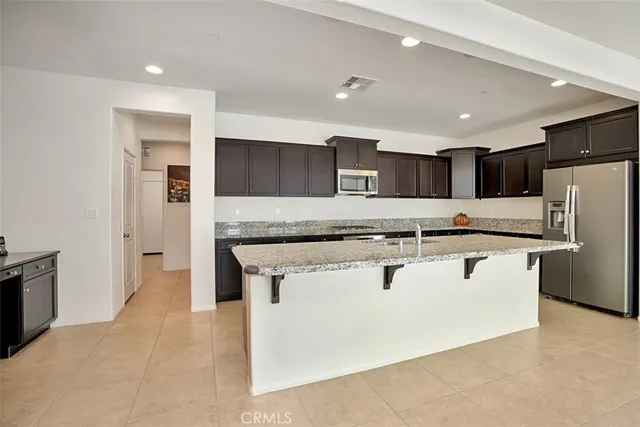 a kitchen with stainless steel appliances a refrigerator sink and microwave