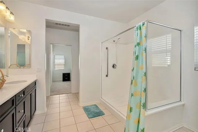 a bathroom with a granite countertop shower a sink and a mirror