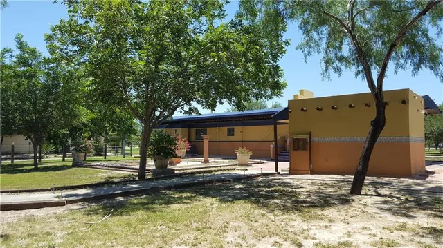 a view of a house with backyard and trees