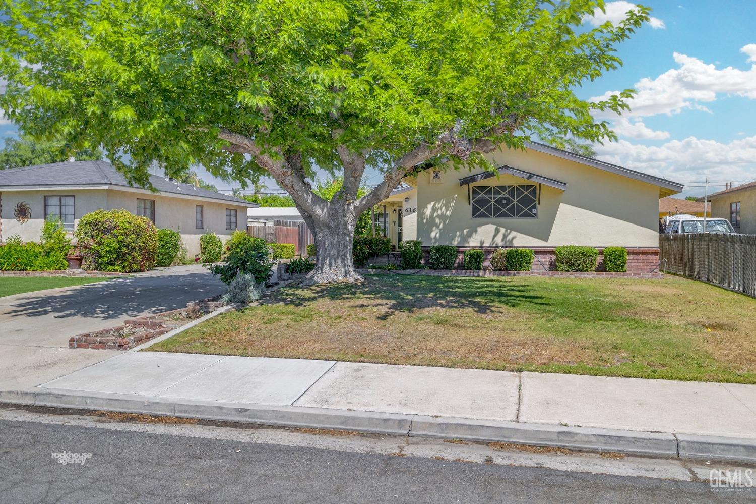 Undisclosed Address Bakersfield, CA 93304 - Photo 2 of 41 front view of house with a yard and potted plants