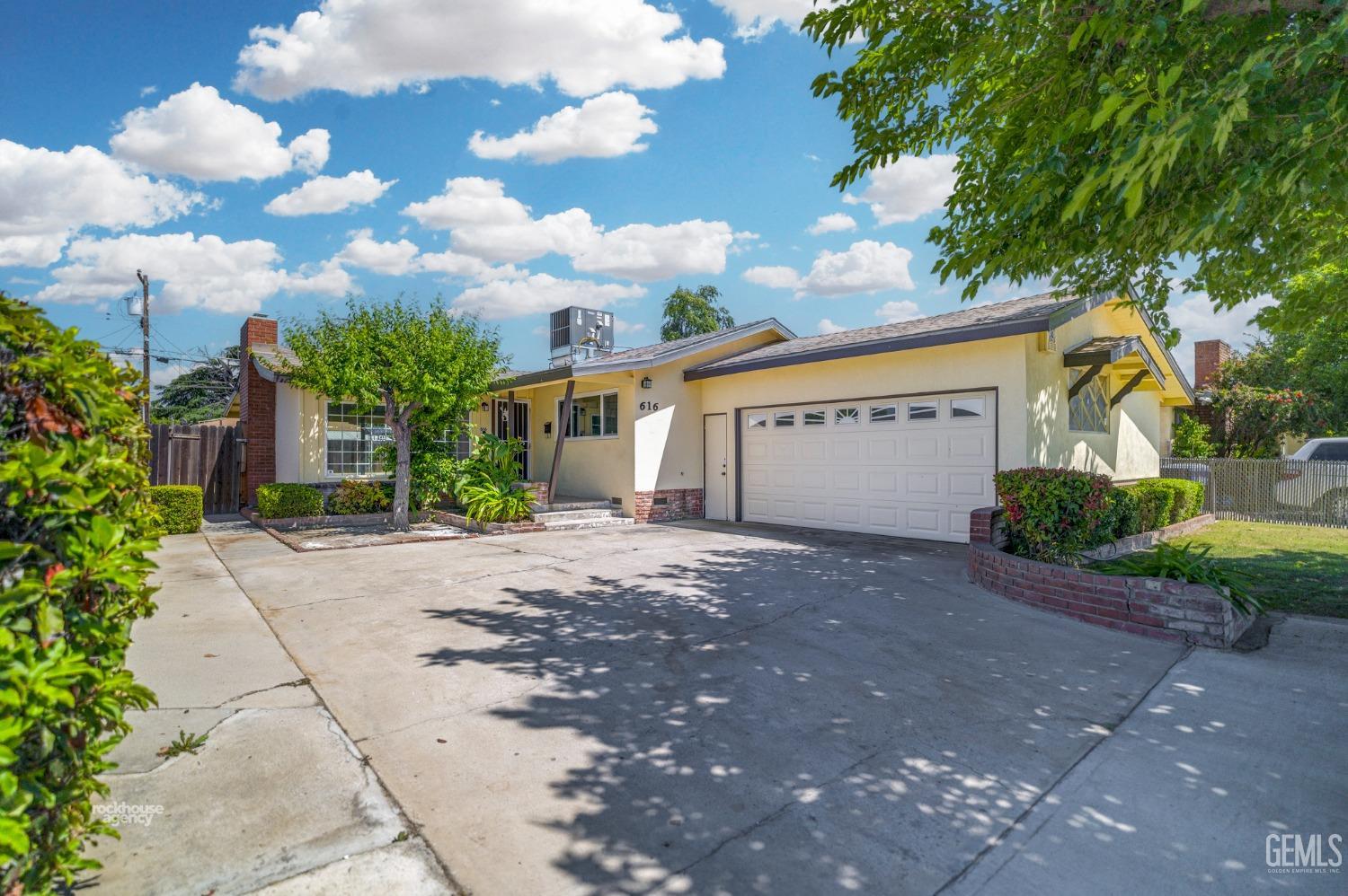 Undisclosed Address Bakersfield, CA 93304 - Photo 5 of 41 a view of a white house with a yard and garage