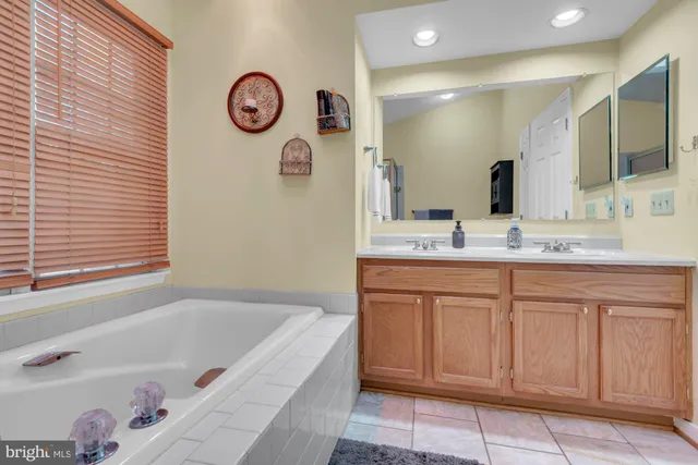 a bathroom with a tub sink and a mirror