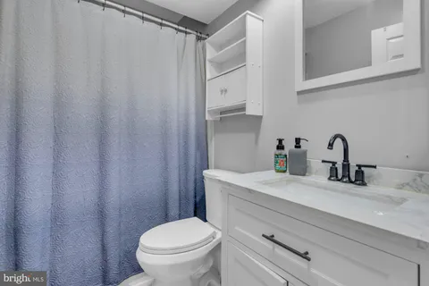 a bathroom with a sink a toilet and a mirror