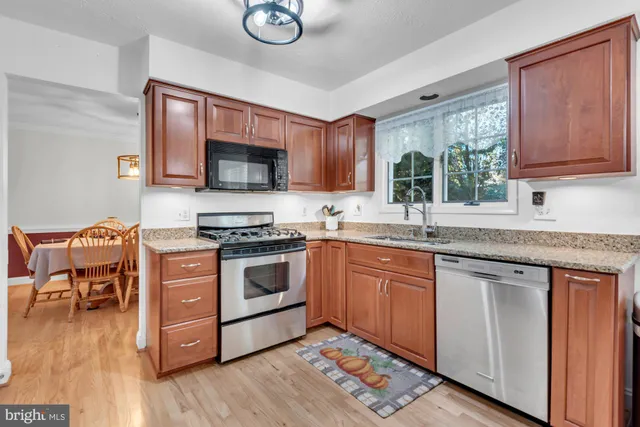 a kitchen with stainless steel appliances kitchen island granite countertop a stove a sink and a microwave