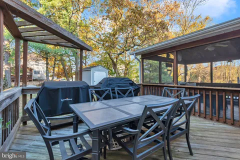 a view of a patio with table and chairs under an umbrella with wooden floor