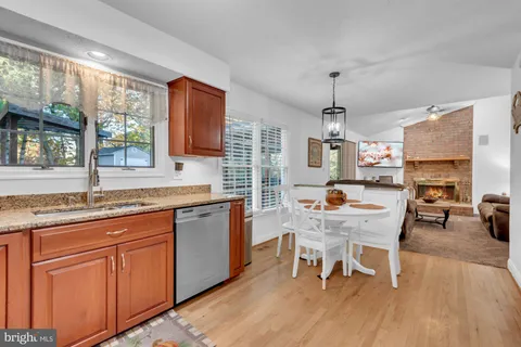 a kitchen with granite countertop stainless steel appliances stove a dining table and chairs