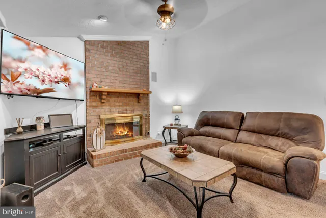 a living room with furniture a flat screen tv and a fireplace