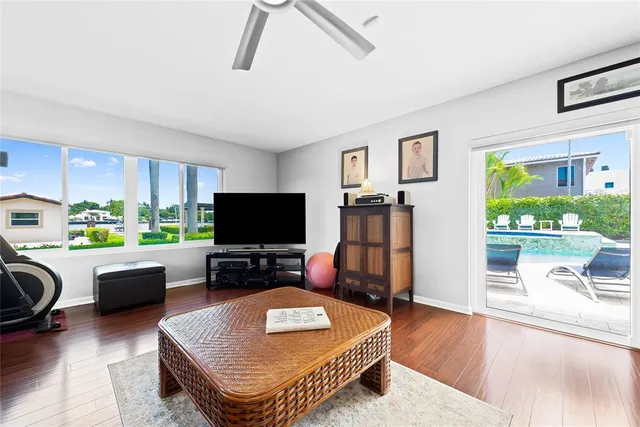 a living room with furniture a flat screen tv and a large window