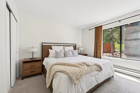 a bedroom with a bed and large window