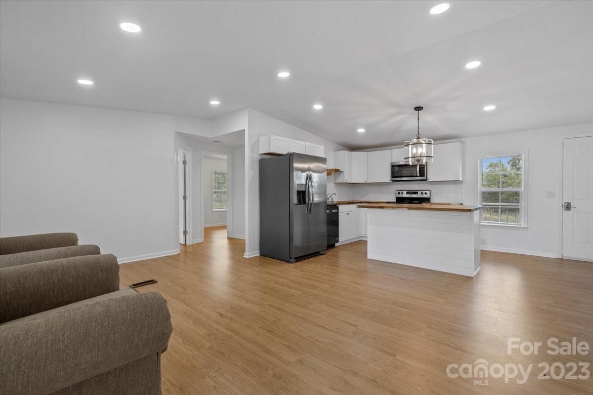 1724 Ruben Road Monroe, NC 28112 - Photo 7 of 28 a living room with stainless steel appliances kitchen island granite countertop a refrigerator and a stove top oven