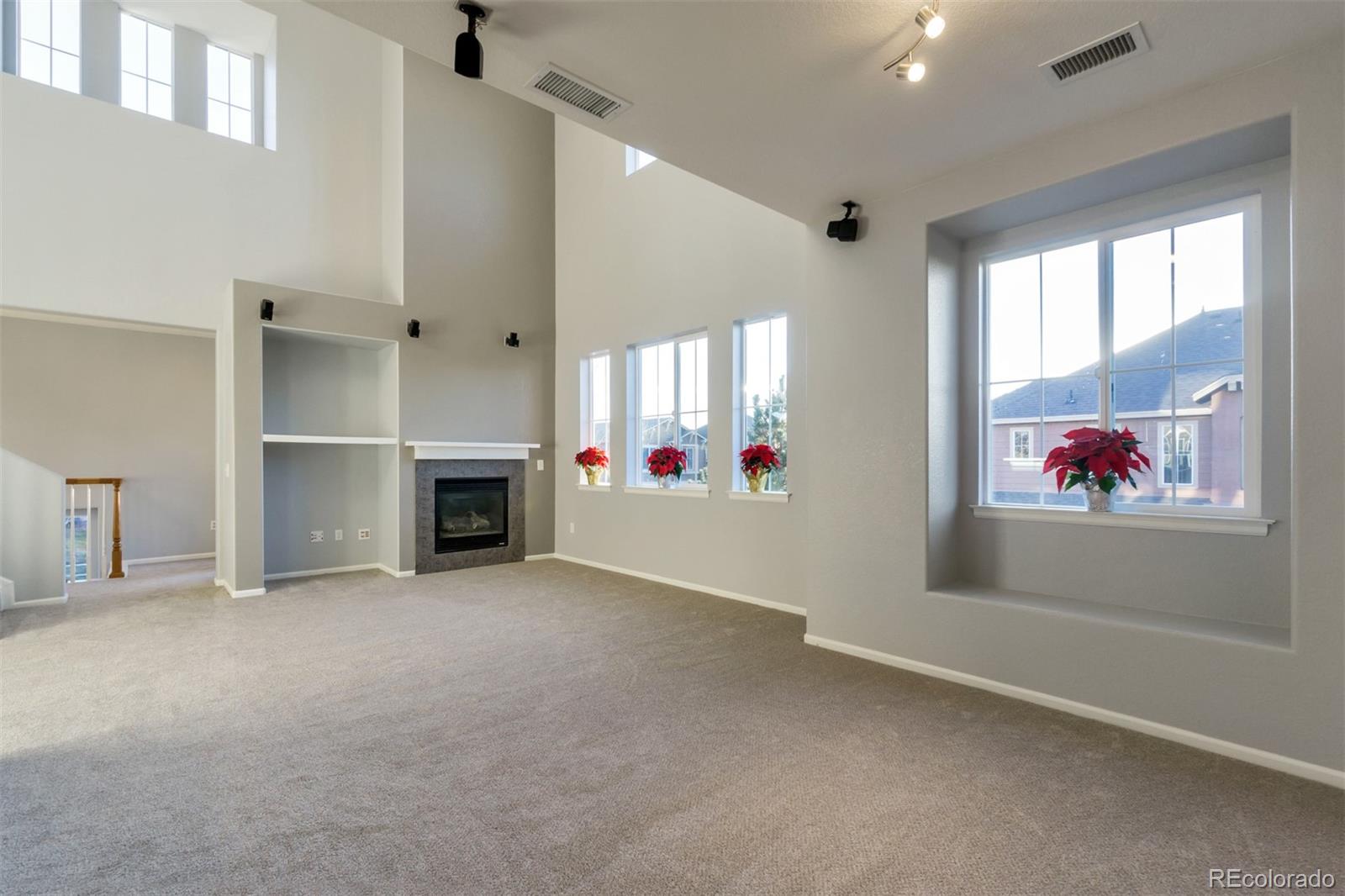 10533 Ashfield Street, Unit D Highlands Ranch, CO 80126 - Photo 2 of 25 an empty room with windows and fireplace