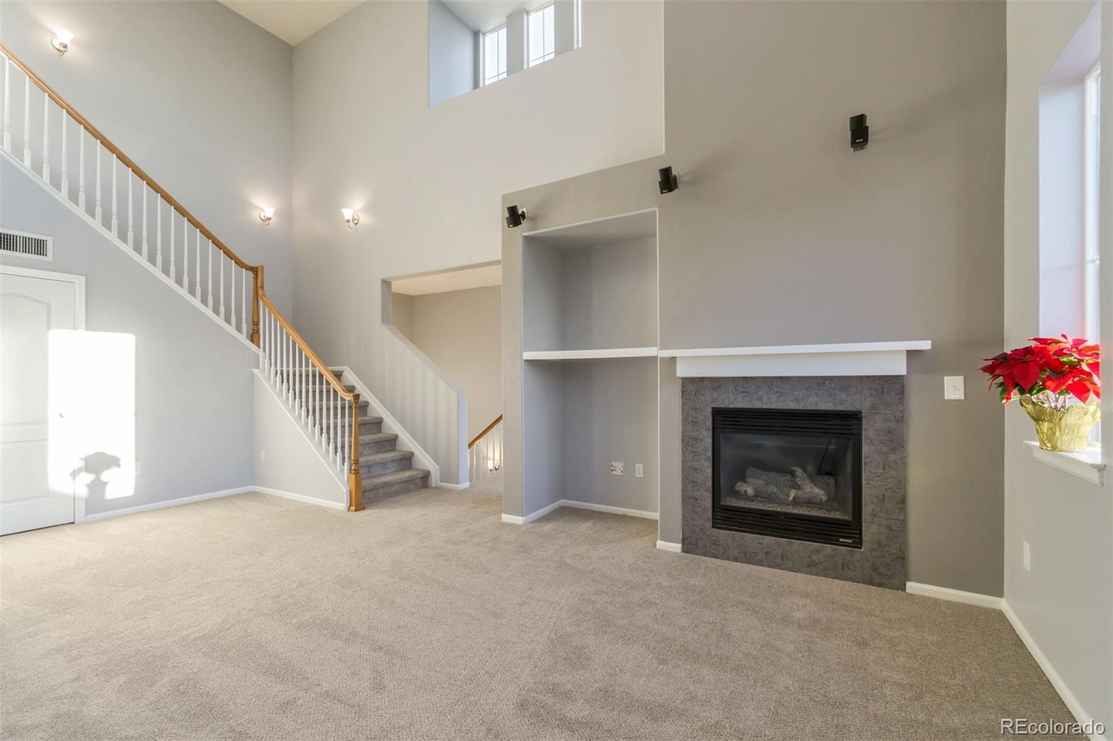 10533 Ashfield Street, Unit D Highlands Ranch, CO 80126 - Photo 4 of 25 a view of an empty room with stairs and a fireplace