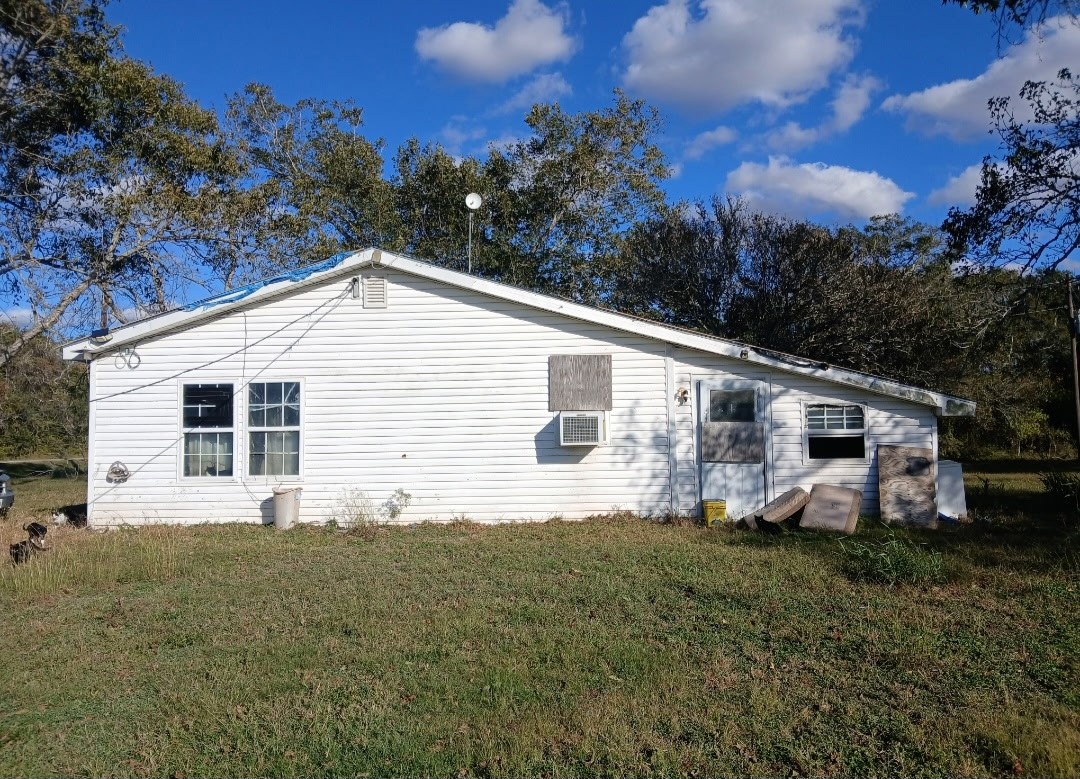 885 Bullock Road Francitas, TX 77961 - Photo 12 of 15 Front/side exterior view of the main white manufactured/mobile home, showing the raised foundation and surrounding grass.