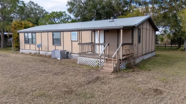 a view of a house with a yard and wooden fence