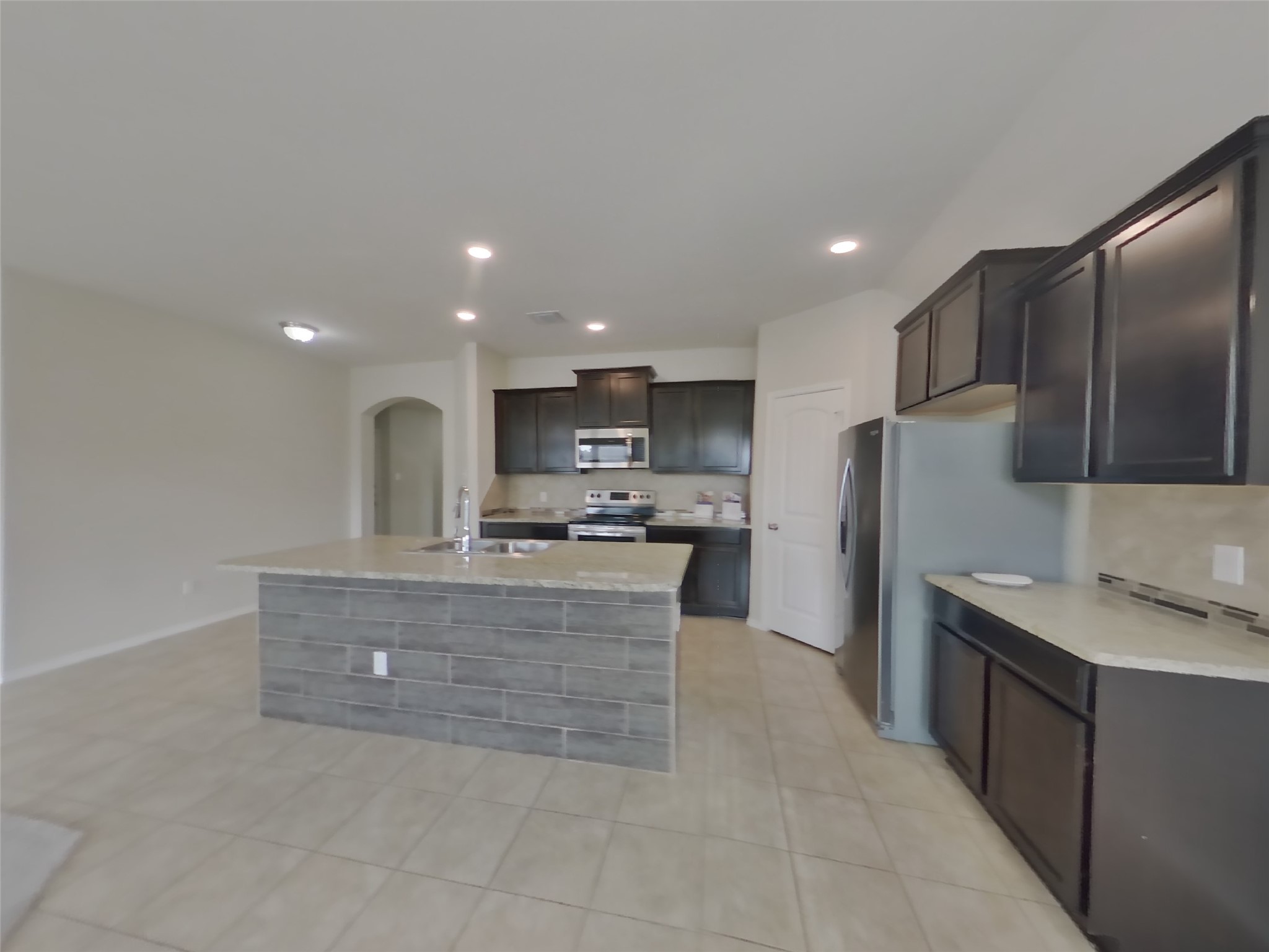 1152 Ibis Falls Loop Jarrell, TX 76537 - Photo 3 of 19 a large kitchen with stainless steel appliances kitchen island granite countertop a refrigerator a sink a stove and a cabinets