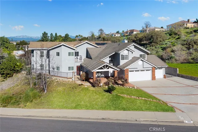 a view of a big house with a big yard and large trees