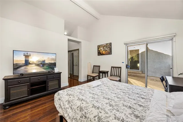 a spacious bedroom with a bed and wooden floor