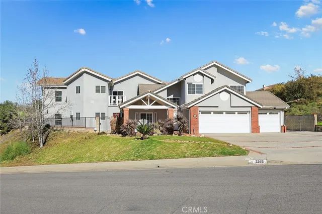 a view of a house with a big yard and large trees