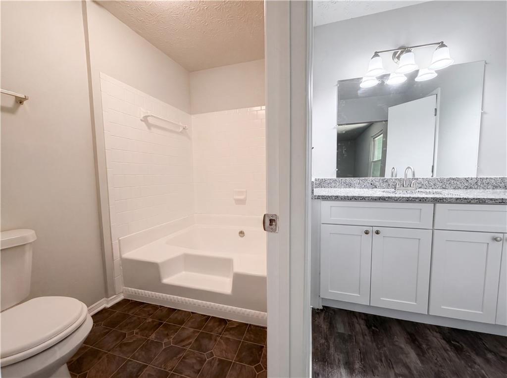 6830 Earlhurst Road Atlanta, GA 30349 - Photo 23 of 27 a bathroom with a granite countertop sink toilet and shower