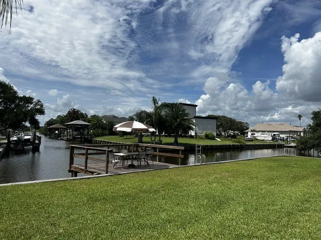 a view of a lake in front of house with green space