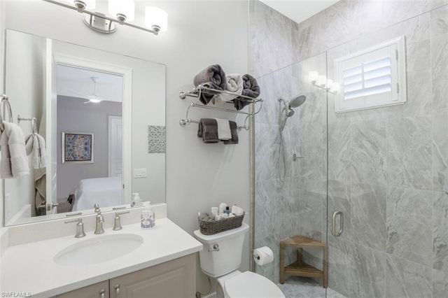 a bedroom with a bed and large windows