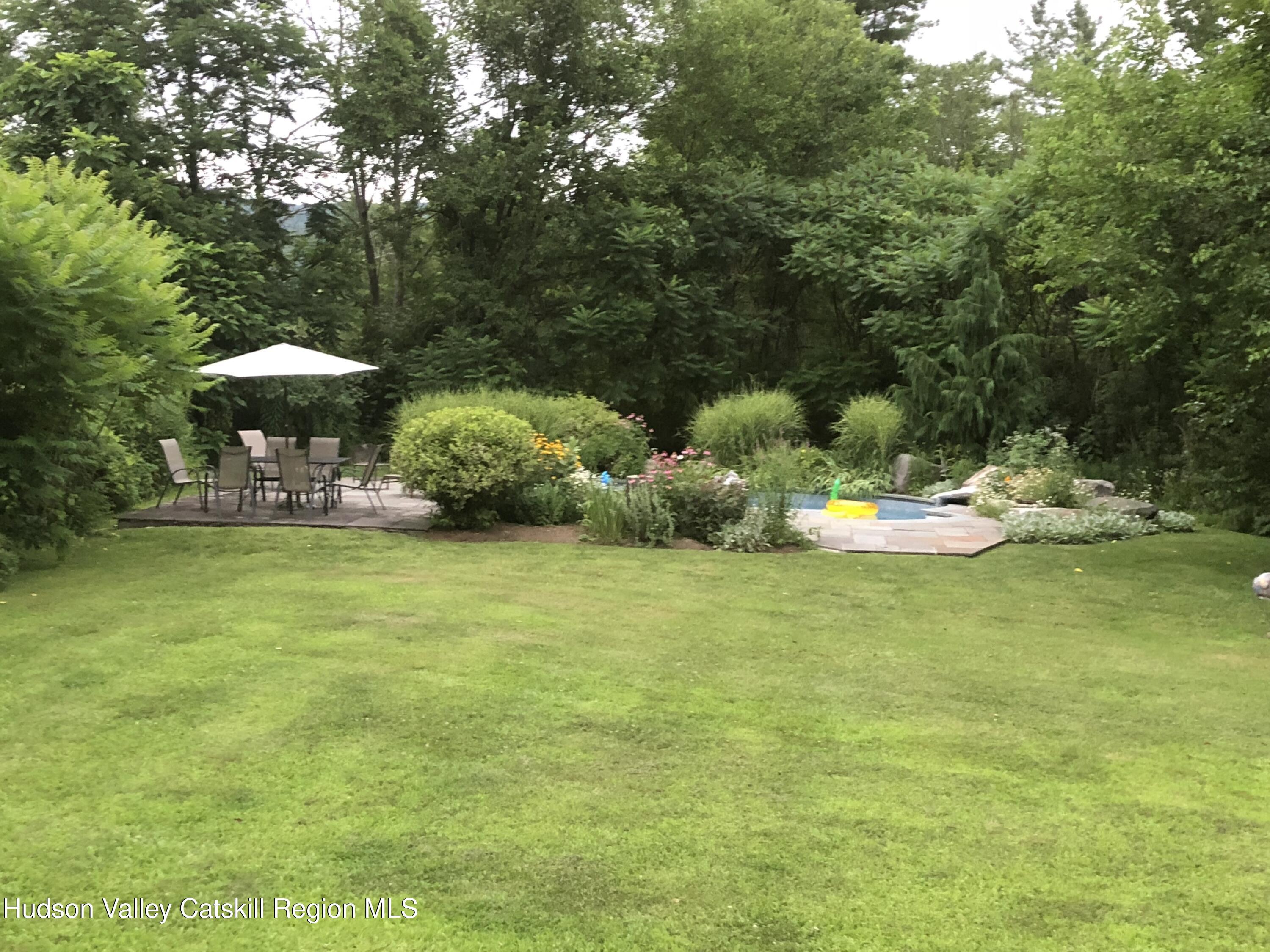 1 Rapp Hill Road New Paltz, NY 12561 - Photo 3 of 45 a backyard of a house with table and chairs under an umbrella
