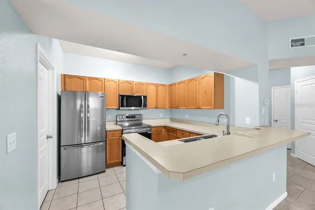 a kitchen that has a sink a stove counter top space and cabinets