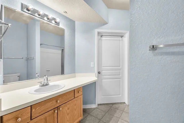 an empty room with chandelier fan and windows