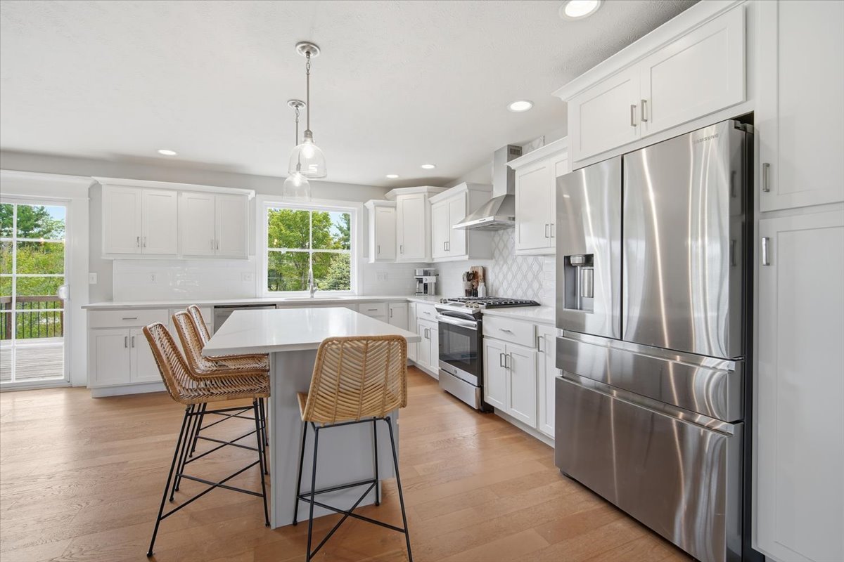 5407 Ferryman Road Bloomington, IL 61705 - Photo 15 of 61 a kitchen with stainless steel appliances a refrigerator a stove a dining table and chairs with wooden floor