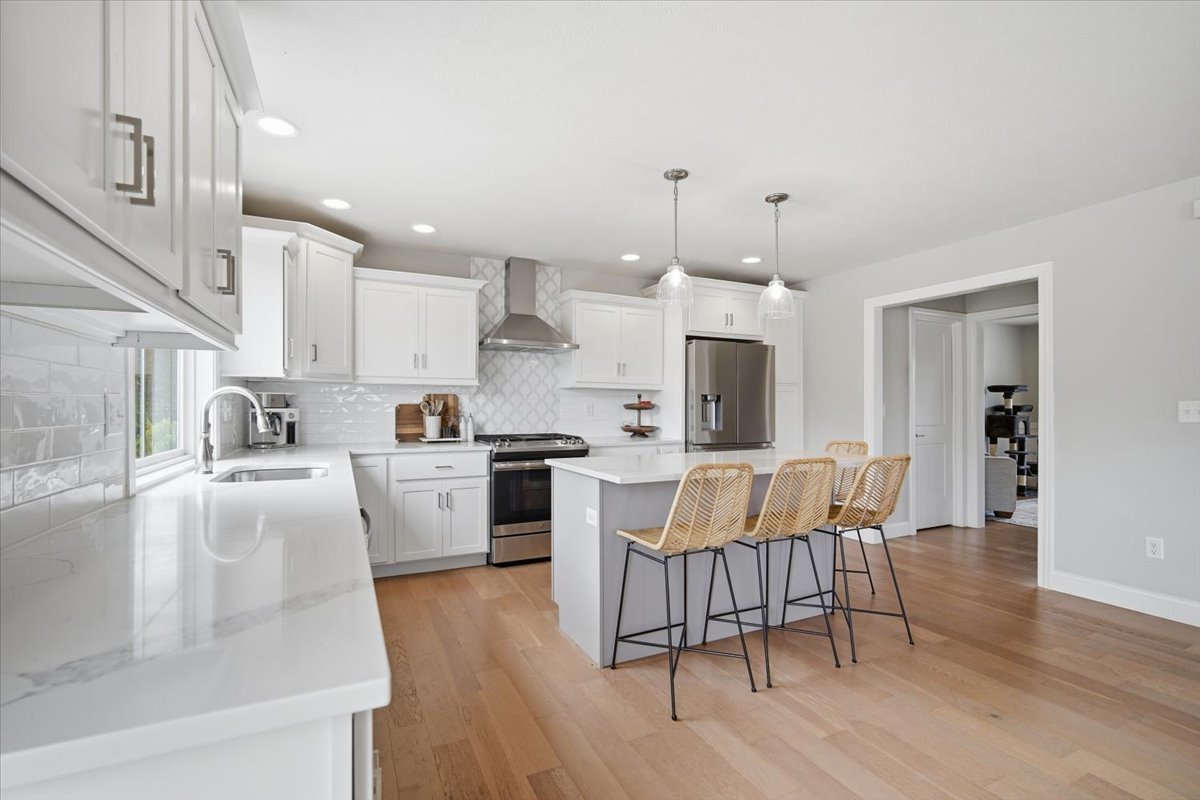 5407 Ferryman Road Bloomington, IL 61705 - Photo 29 of 61 a large white kitchen with lots of counter space dining table and stainless steel appliances