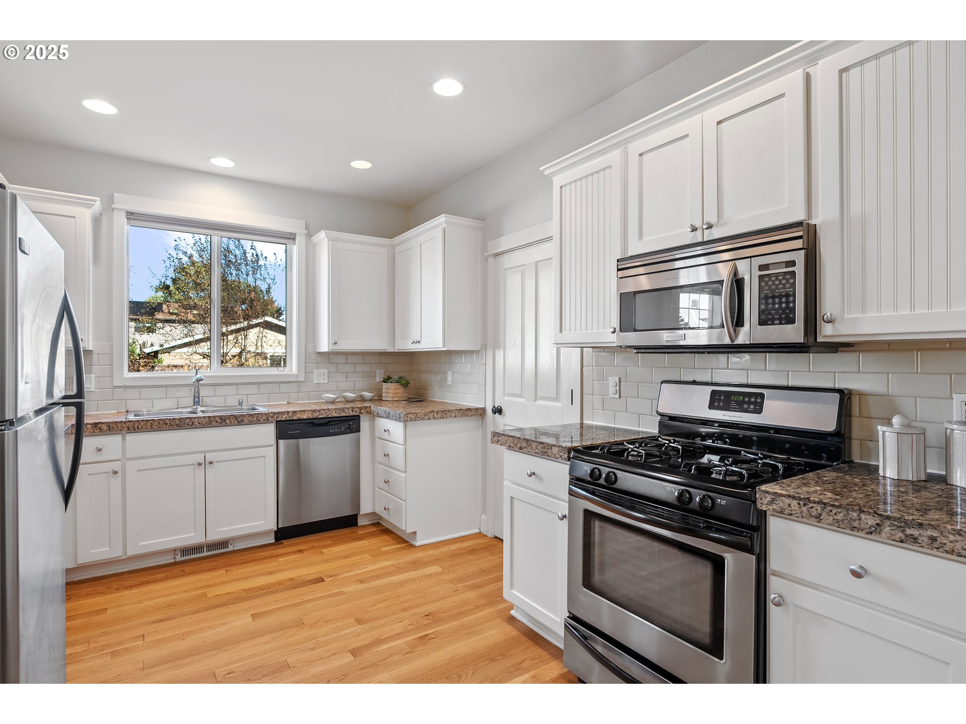 4646 North Commercial Avenue Portland, OR 97217 - Photo 15 of 31 a kitchen with stainless steel appliances granite countertop a stove a sink and a microwave
