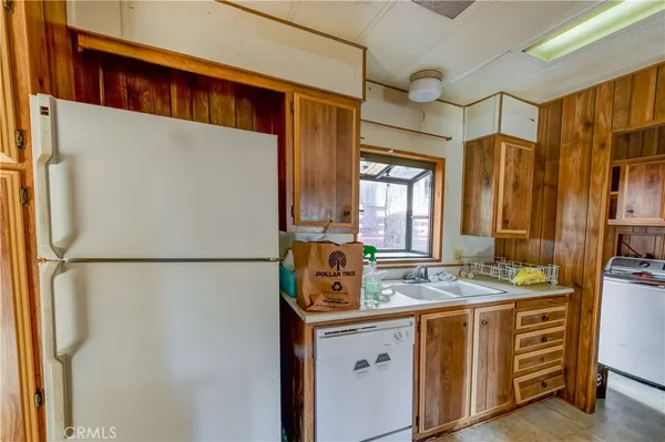 a bathroom with a refrigerator sink and mirror